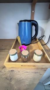 a blue coffee pot on a wooden tray with three bowls at The Muizenberg Muse in Muizenberg