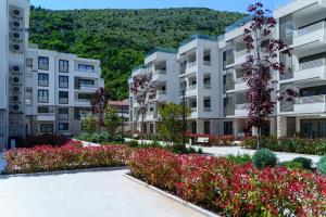 a row of apartment buildings with flowers in a courtyard at Apartments with Pool 5 Min Walk to Beach in Igalo