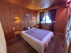 a bedroom with a bed in a wooden room at La chambre Chez Marion 2 personnes in Notre-Dame-de-Bellecombe