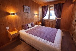 a bedroom with a bed in a wooden room at La chambre Chez Marion 2 personnes in Notre-Dame-de-Bellecombe
