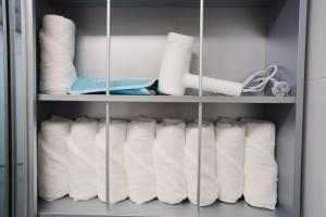 a closet filled with white towels and toilet paper at Guri 365 Stay in Guri