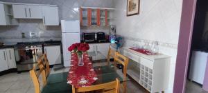 a kitchen with a table with flowers on it at Ótima casa 3 quartos, piscina, bem localizada in Foz do Iguaçu