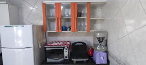 a small kitchen with a microwave and a coffee maker at Ótima casa 3 quartos, piscina, bem localizada in Foz do Iguaçu