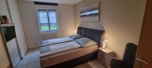 a small bedroom with a bed and a window at Ferienwohnung Frate in Velden am Wörthersee