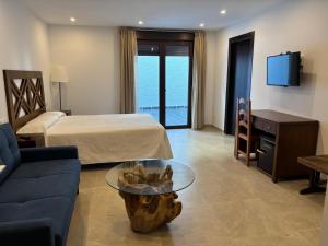 a hotel room with a bed and a couch and a table at Hostal Mulhacén in Trevélez