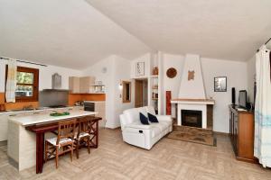 a kitchen and a living room with a fireplace at Stazzo La Chèa in Nuragheddu