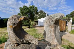 a statue of a rock in front of a building at Stazzo La Chèa in Nuragheddu +8 photos