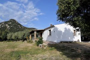 a white house with a mountain in the background at Stazzo La Chèa in Nuragheddu
