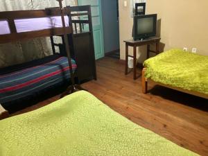 a room with two bunk beds and a television at Imperio Carlos V in Oruro +4 photos