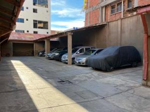 a parking lot with cars parked next to a building at Imperio Carlos V in Oruro