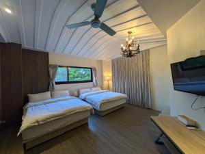 a bedroom with two beds and a ceiling fan at 羅東夏林5號 in Luodong