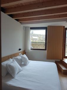 a bedroom with a large white bed with a window at Benaki 99 in Ladines