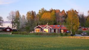 a large red house in the middle of a field at Borgen Panorama, A Scenic Getaway in Stockholm