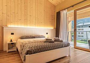 a bedroom with a bed and a large window at Ciasa Fatati' in Pinzolo
