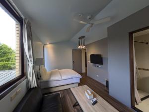 a room with a bed and a couch and a window at 羅東夏林5號 in Luodong
