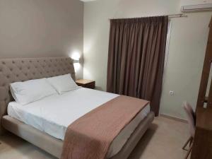 a bedroom with a bed and a large window at K & A Studios 2 in Nydri