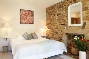 um quarto com uma cama e uma parede de tijolos em Chambres Aux Sabots Rouges em Guéméné-sur-Scorff