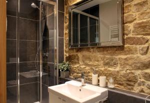 y baño con lavabo y ducha con espejo. en Chambres Aux Sabots Rouges en Guéméné-sur-Scorff