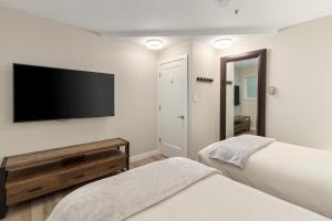 a bedroom with two beds and a flat screen tv at Glacier Lodge in Whistler +14 photos