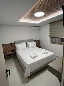 a bedroom with a large bed with white sheets at Latsis Suites in Plytra