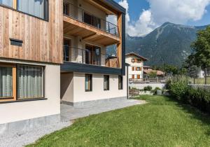 a house in the mountains with a green yard at Ciasa Fatati' in Pinzolo