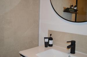 a bathroom sink with two bottles of wine on it at Vakantie Hermansheuvel in Bekkevoort +31 photos
