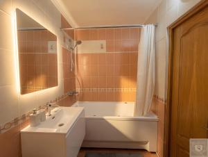 a bathroom with a tub and a sink and a toilet at RentHouse Apartments Metropolis in Chişinău +25 photos