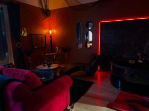 a living room with a couch and red lights at Maison love rooms in Tours