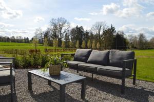 a couch and a table on a gravel patio at Vakantie Hermansheuvel in Bekkevoort