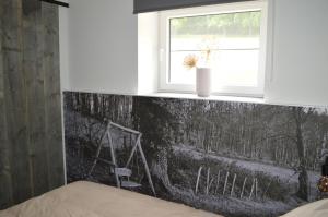 a bedroom with a black and white wall with a window at Vakantie Hermansheuvel in Bekkevoort
