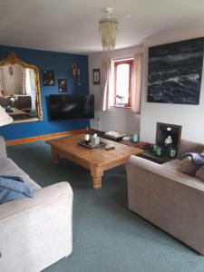 a living room with a coffee table and a couch at Priory Stream, Lower Priory, Pembrokeshire in Milford Haven