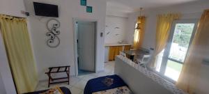 a living room with a chair and a kitchen with a window at Villa Flavia - Adults Only in Ponza