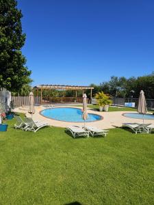 a pool with chairs and umbrellas in a yard at Casa de Playa Hatillo in Hatillo