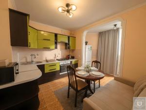 a kitchen and dining room with a table and chairs at RentHouse Apartments Metropolis in Chişinău