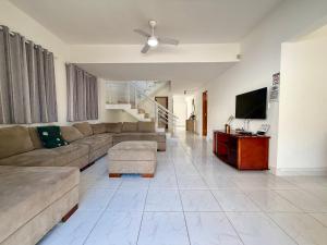 a living room with a couch and a flat screen tv at Casa virgínia enseada in Guarujá