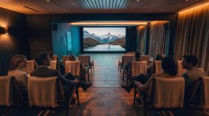 a group of people sitting in chairs watching a movie at Beatenberg Resort & Spa in Beatenberg Interlaken in Beatenberg