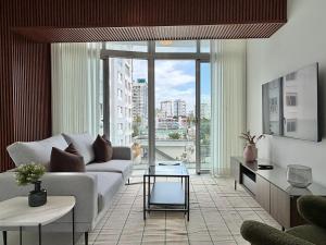 a living room with a couch and a large window at Shalom Suites by Yellowkey in Santo Domingo