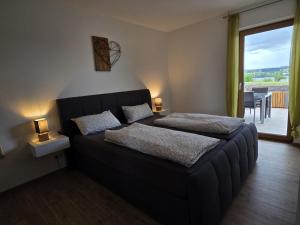 a bedroom with two beds and a large window at RoSa Haus in Steingaden