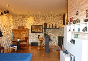 a living room with stone walls and a fireplace at Rahoni Park & Apartments in Dhërmi