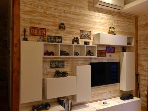 a living room with a tv and a wooden wall at Rahoni Park & Apartments in Dhërmi +72 photos