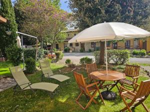 a table and chairs with an umbrella in the yard at Tuscany Hill in Gambassi Terme