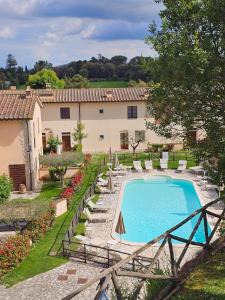 a pool in a yard with chairs and a building at Tuscany Hill in Gambassi Terme