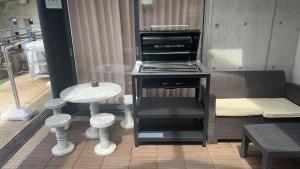 a kitchen with a grill and a table and a stool at BRUCE Luxury House in Izumi-Sano