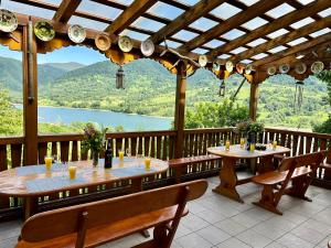 two tables on a deck with a view of a lake at Cabana Wittmann in Rusca