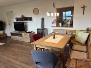 a living room with a wooden table and a television at Garten Apartment Diwoky in Sankt Gilgen