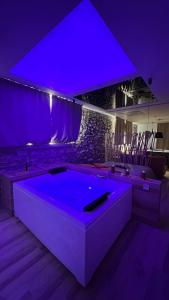 a purple room with a large tub in a room at Suite spa civico 4 in Follonica