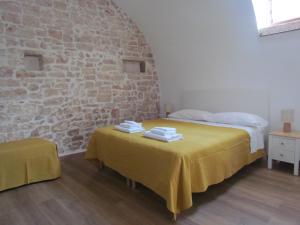 a bedroom with two beds and a brick wall at Arco Michele in Putignano