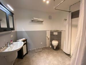 a bathroom with a sink and a toilet at Wohnung am Rande der Nordheide in Welle +3 photos