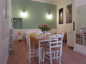 a dining room with a table and white chairs at Arco Michele in Putignano