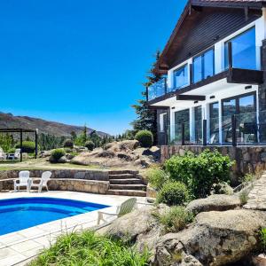 a home with a swimming pool and a house at Suites de la Colina in La Cumbrecita